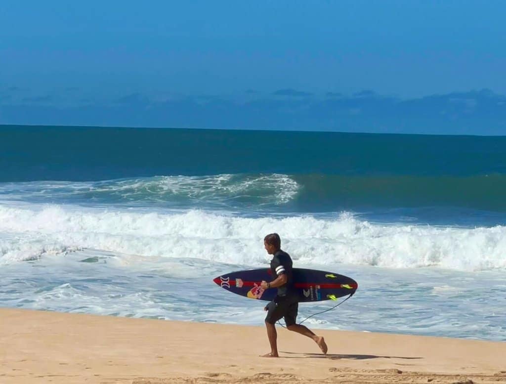 kai lenny on the beach of oahu in north shore surfing