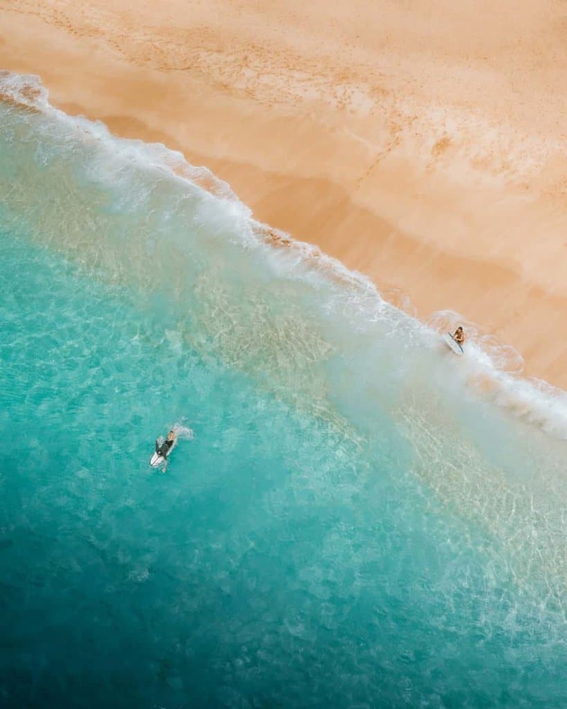 surfer paddling out into an Oahu beach