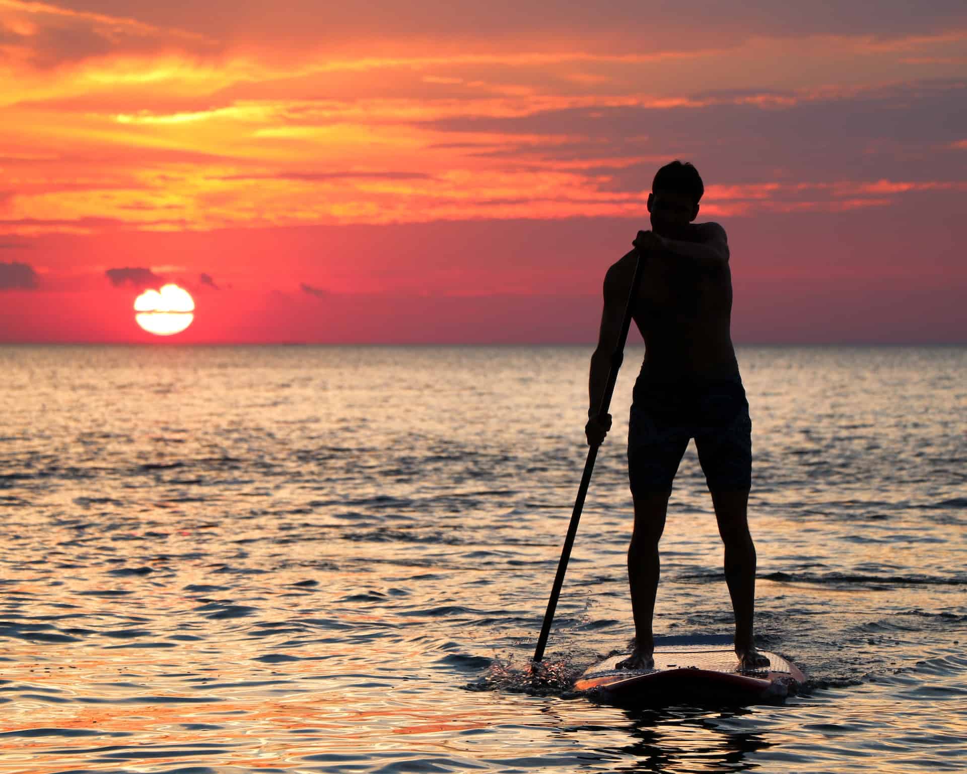 stand up paddle boarding during sunset