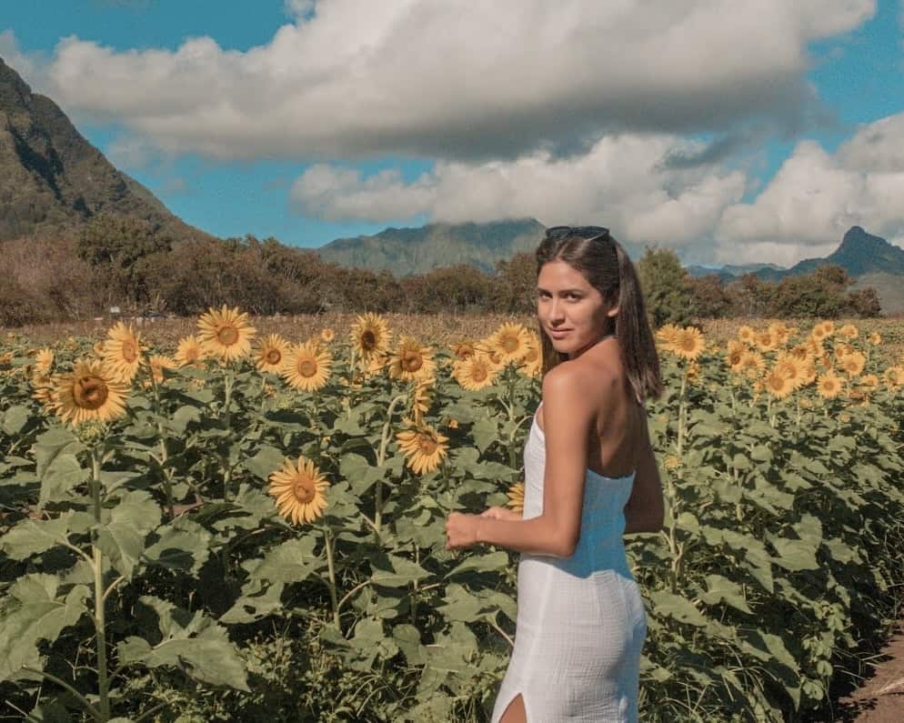 Bridget Gutierrez, a travel blogger wearing a white dress at Waimanalo Country Farms in Oahu.
